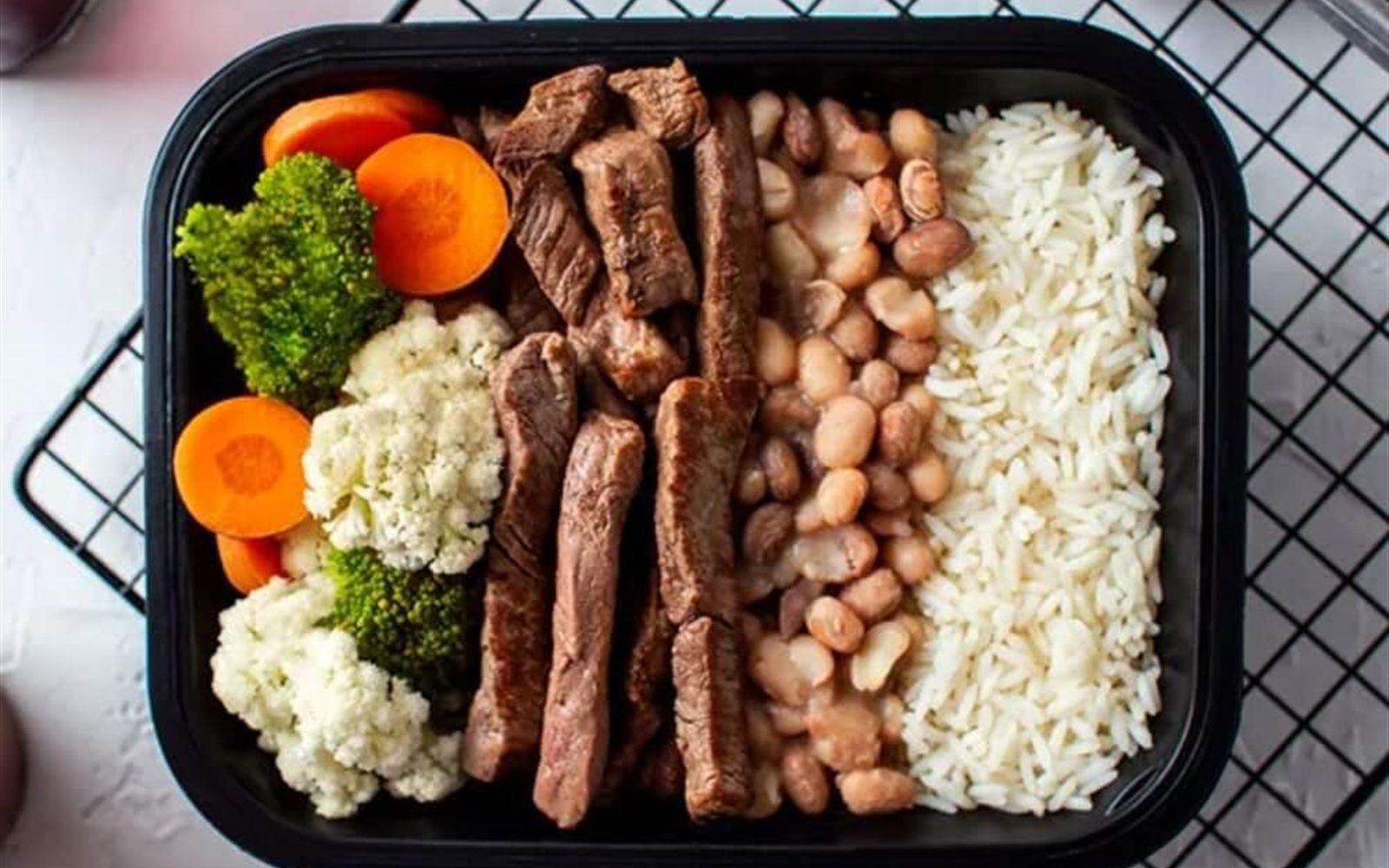 Marmita fitness com carne, arroz, feijão e legumes em bandeja